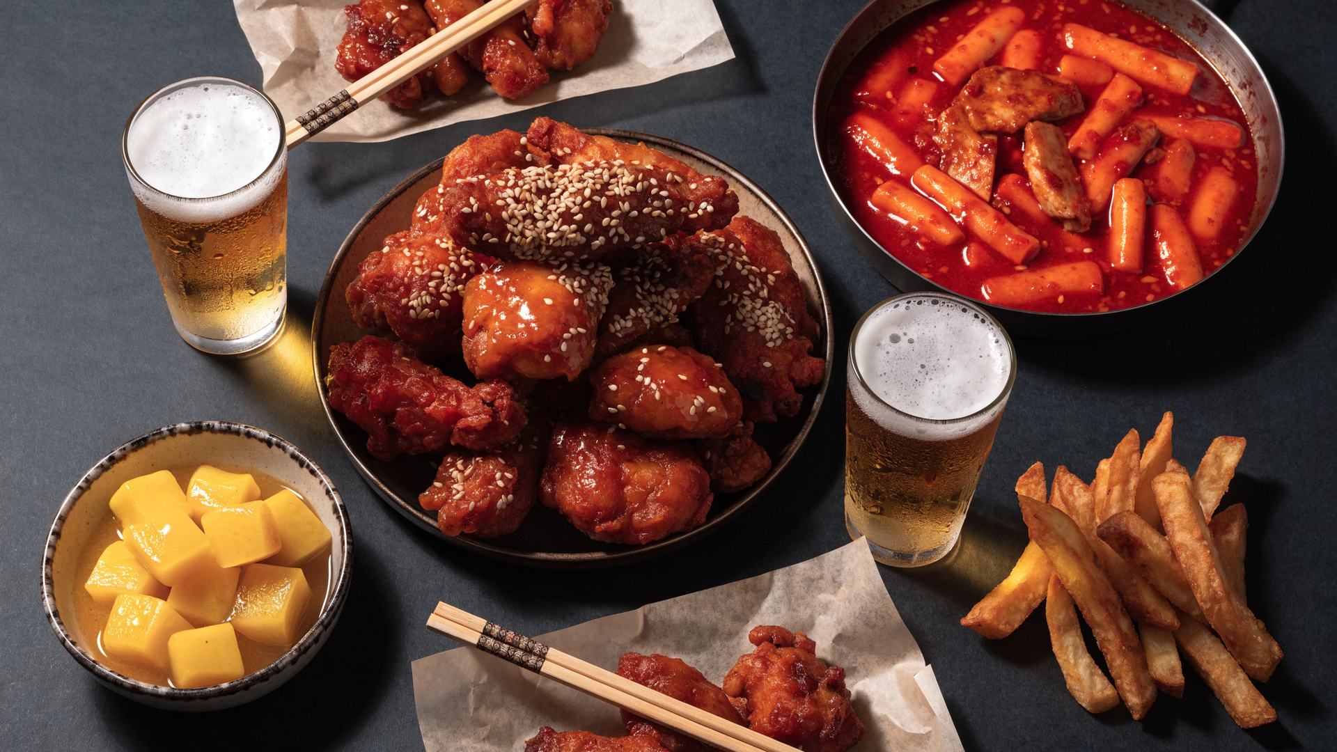 Shared platter of Korean chicken, tteokbokki and beer