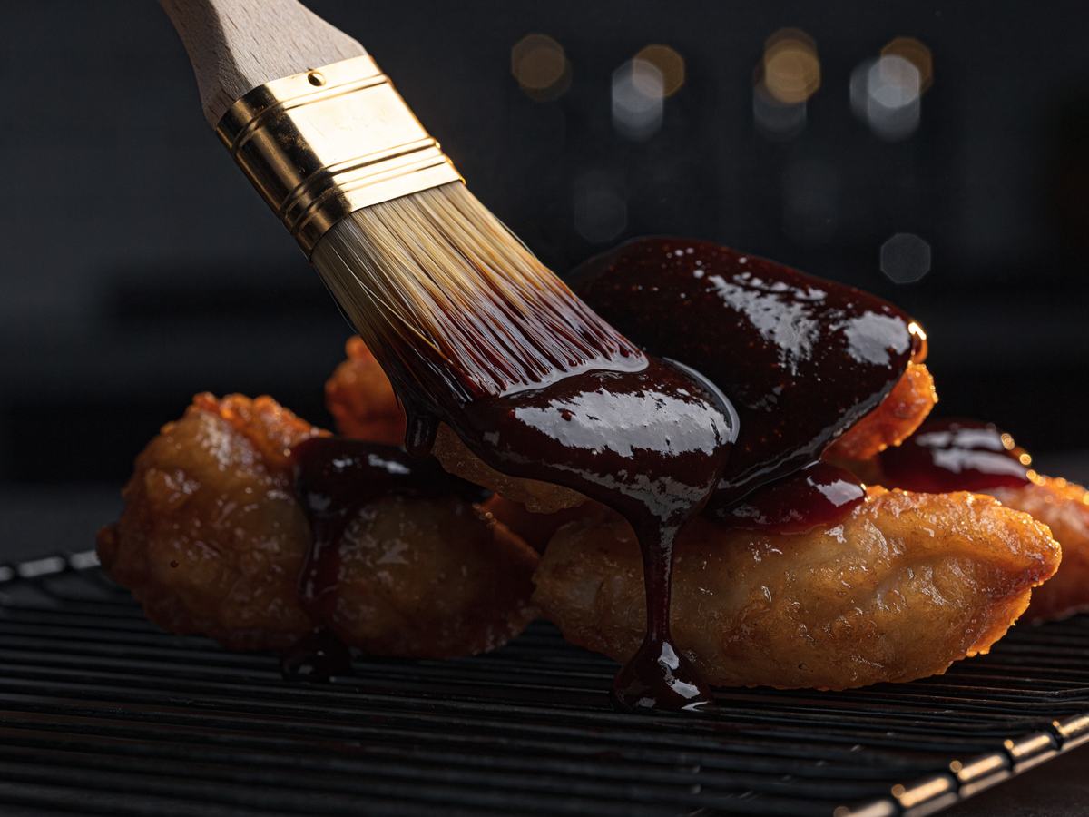 Red chilli glaze brushed onto fried chicken